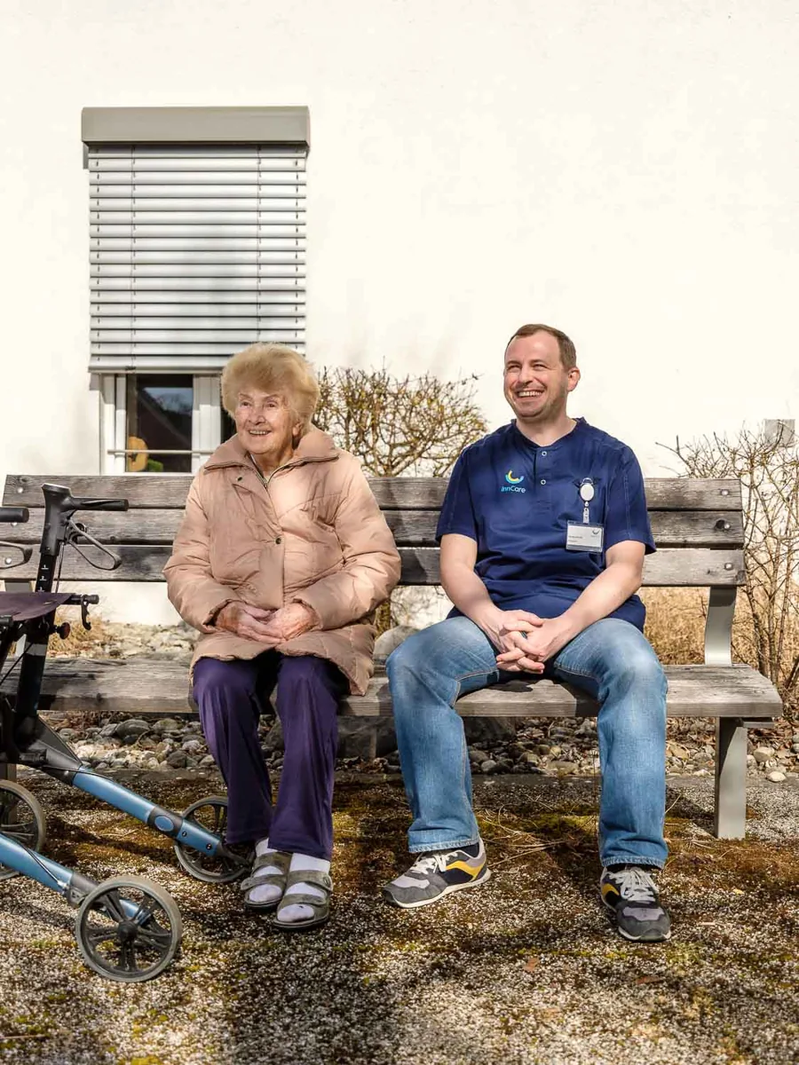 Ein Pflegegast und ein Mitarbeiter von InnCare im Garten